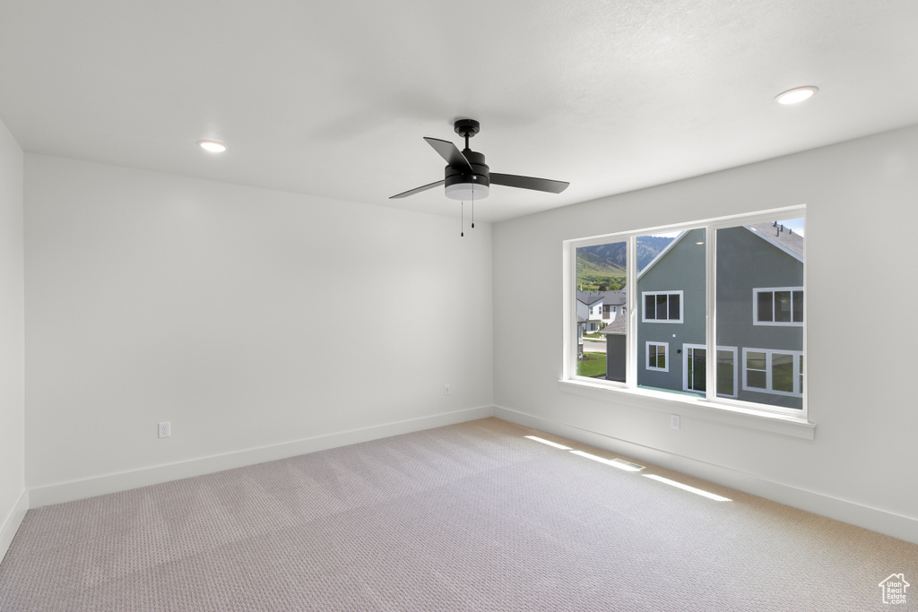 Carpeted spare room with a ceiling fan and recessed lighting