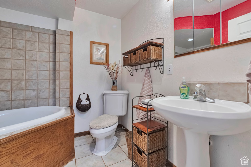 Bathroom with a tub to relax in and tile patterned floors