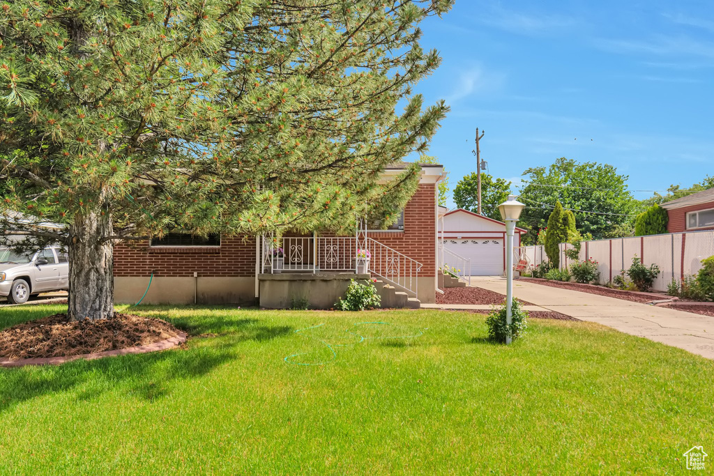 Obstructed view of property with a porch, brick siding, a garage, and concrete driveway
