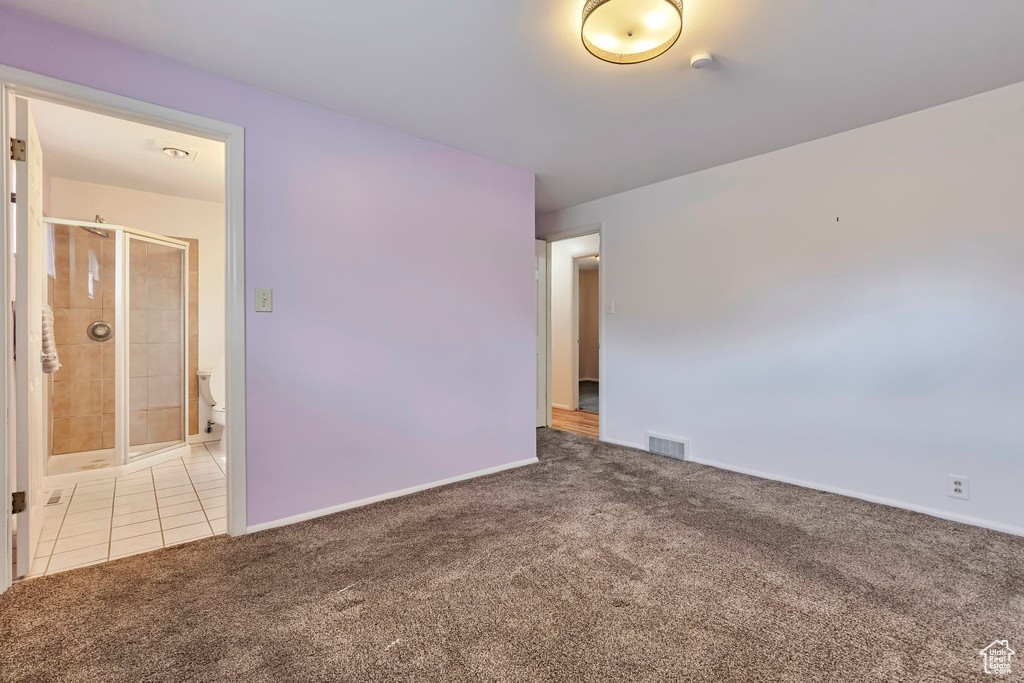 Empty room with carpet floors, a smoke detector, and tile patterned flooring