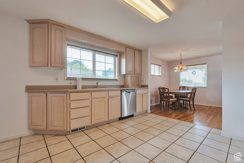Kitchen with light brown cabinetry, dishwasher, a chandelier, and light wood-style floors
