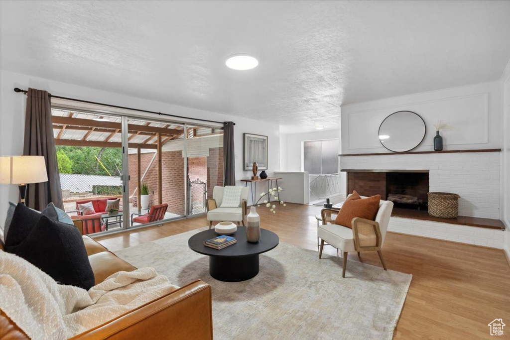 Living area with a fireplace, wood finished floors, and a textured ceiling