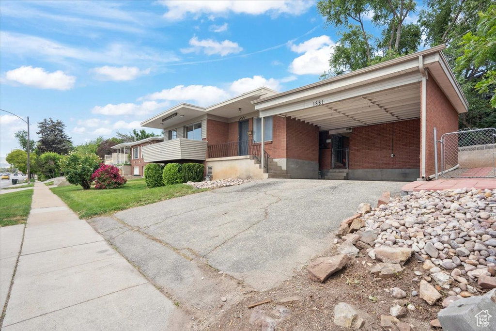 View of front of house featuring brick siding and asphalt driveway