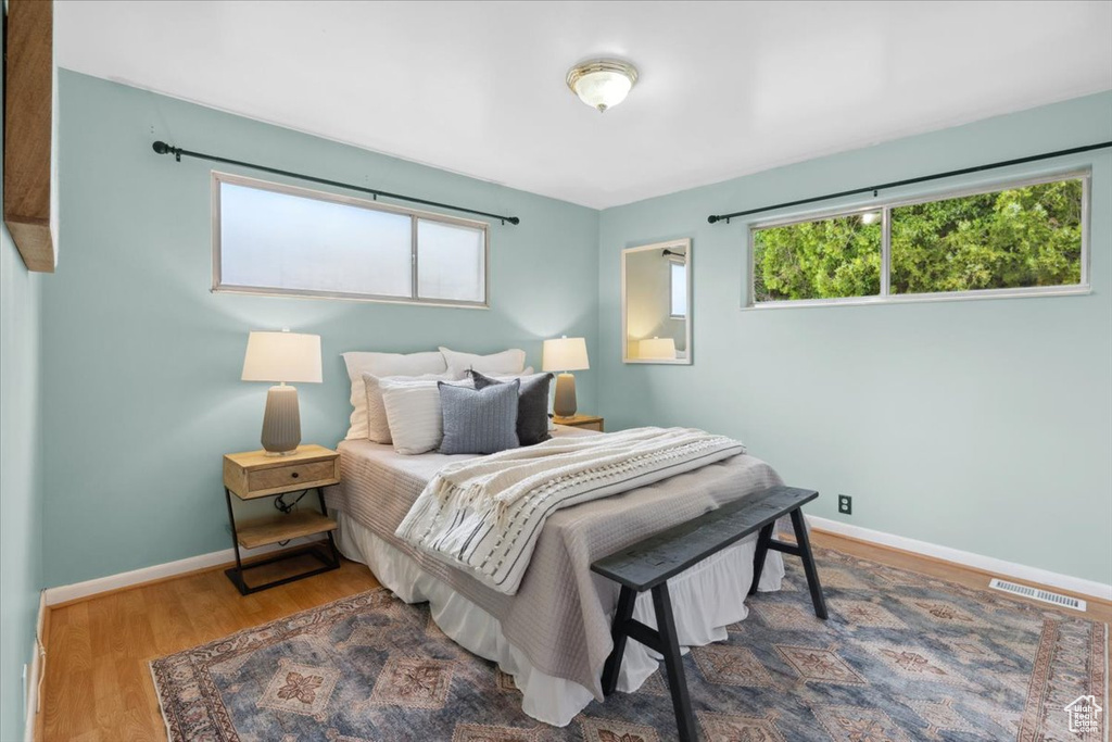 Bedroom with multiple windows and wood finished floors