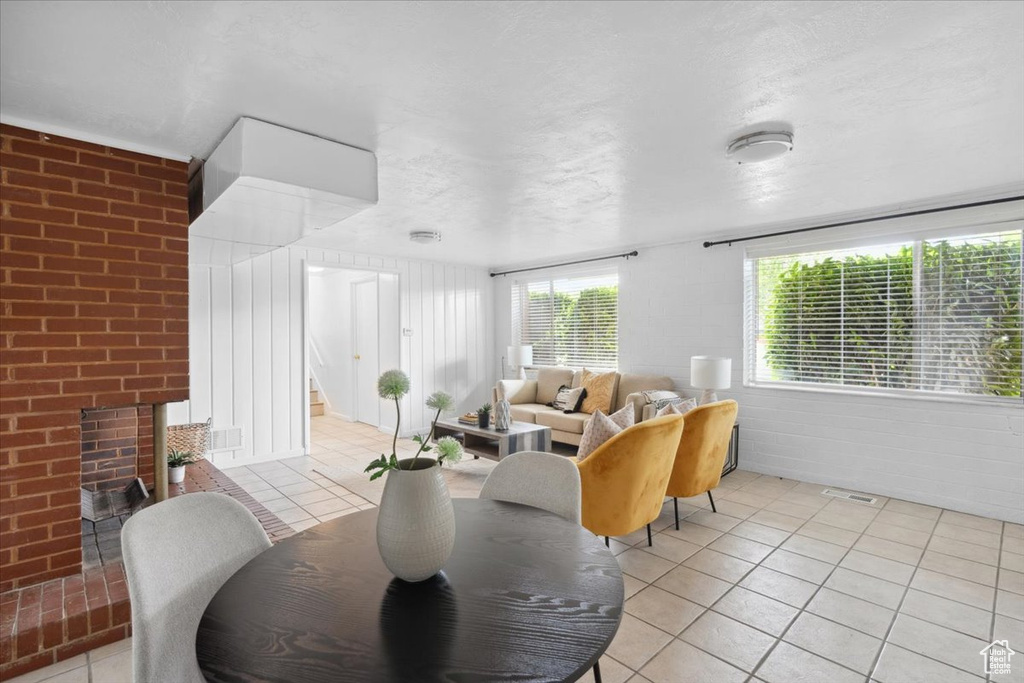 Living area with light tile patterned floors, a fireplace, and stairway