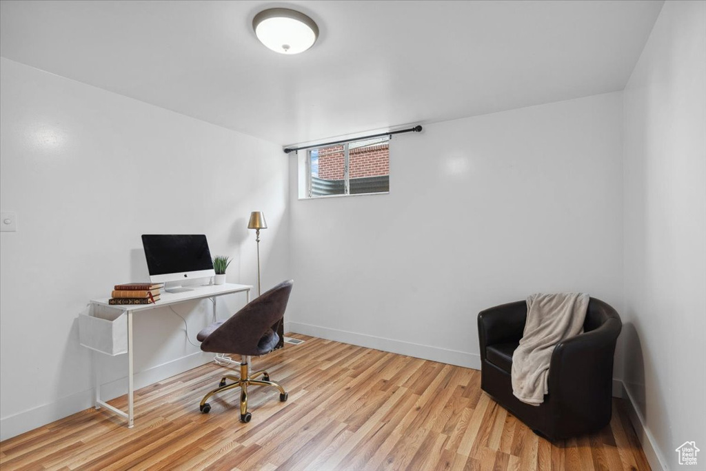 Office area with light wood-style flooring and baseboards