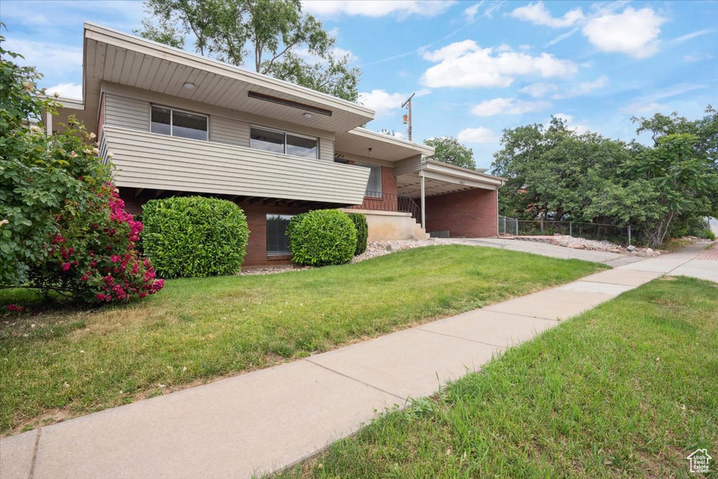 Tri-level home featuring an attached carport