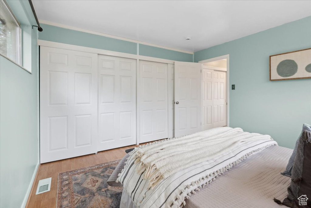 Bedroom featuring wood finished floors and a closet