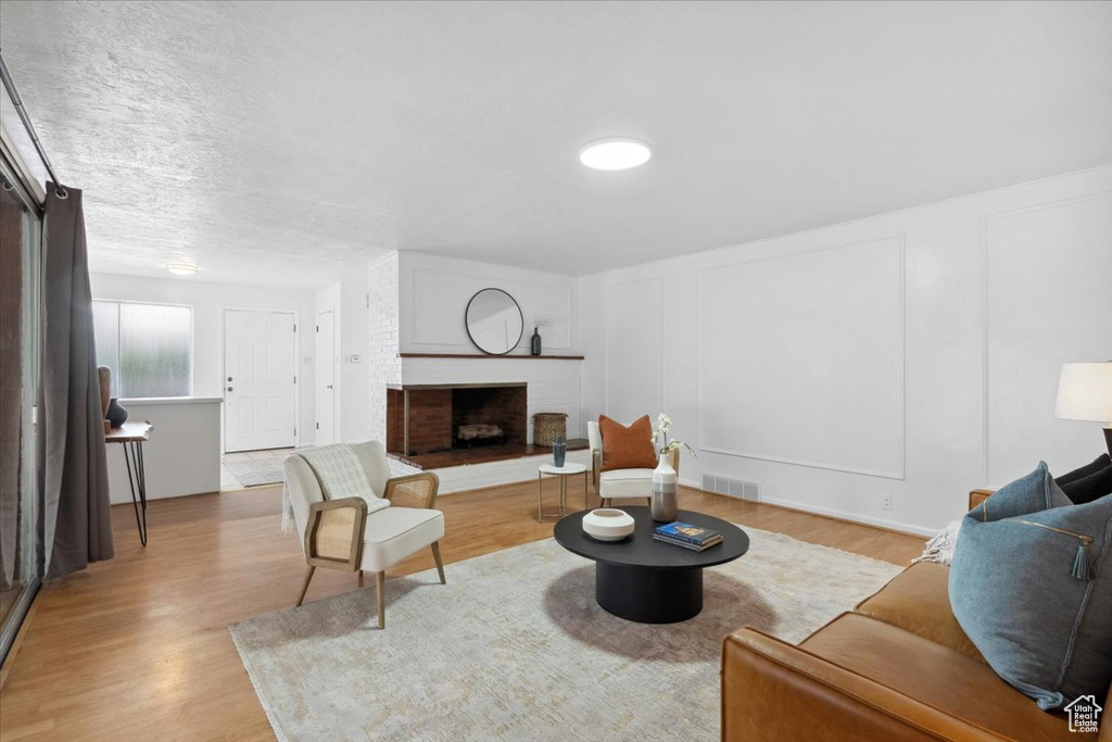 Living area with wood finished floors and a brick fireplace