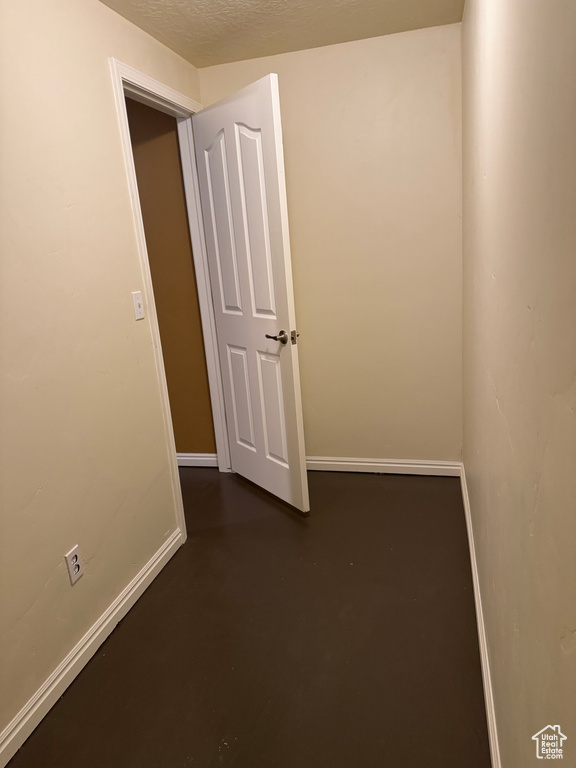 Unfurnished room with concrete flooring and baseboards
