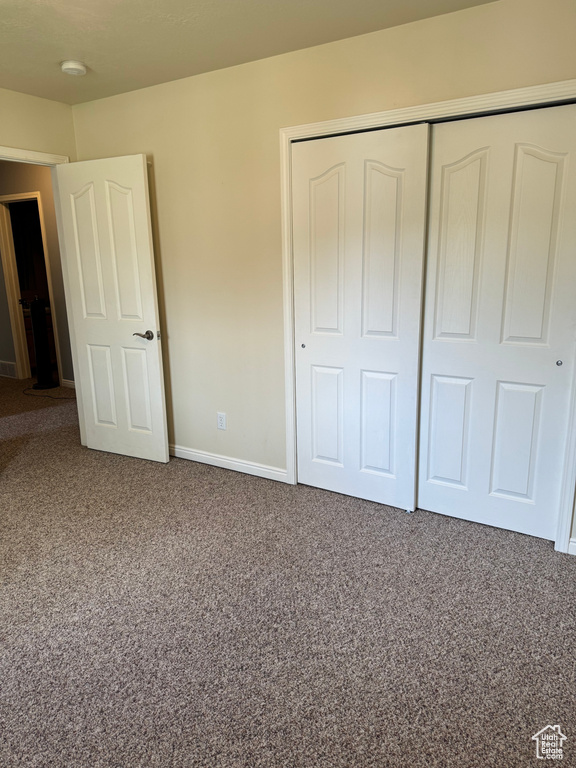Unfurnished bedroom with a closet and carpet floors