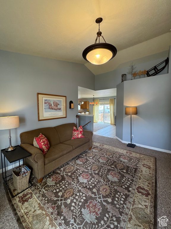 Carpeted living room featuring baseboards and lofted ceiling