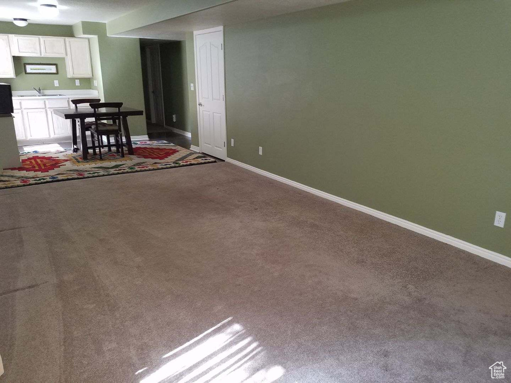 Carpeted living area with baseboards and a sink