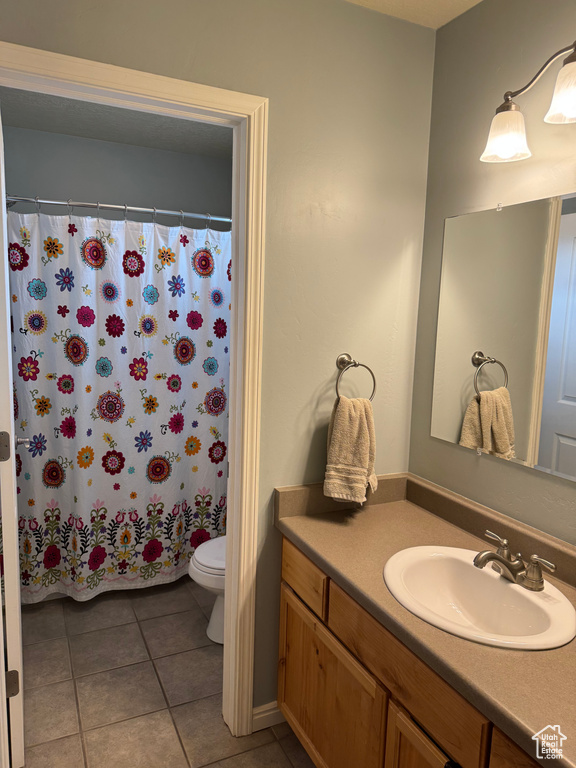 Full bath with vanity, tile patterned floors, and curtained shower