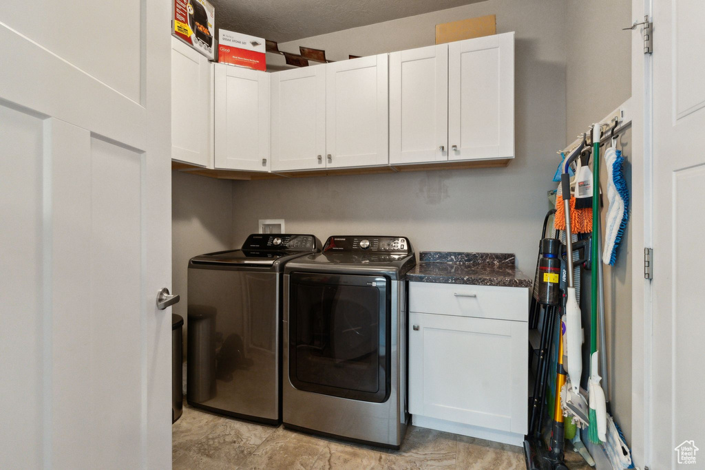 Washroom featuring cabinet space and washing machine and dryer
