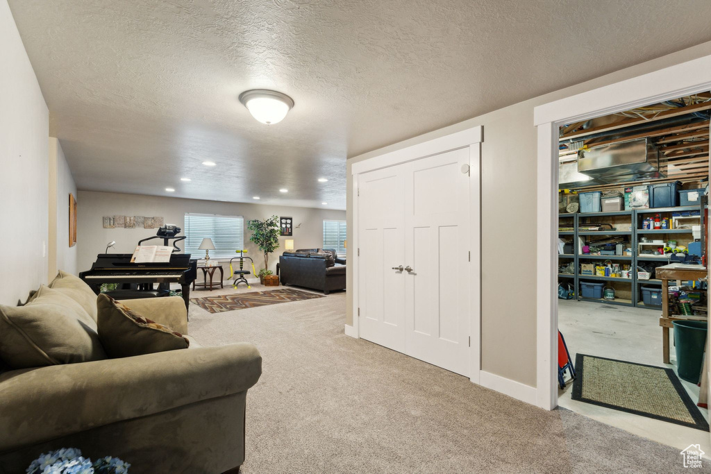 Living room featuring carpet flooring, a textured ceiling, and recessed lighting
