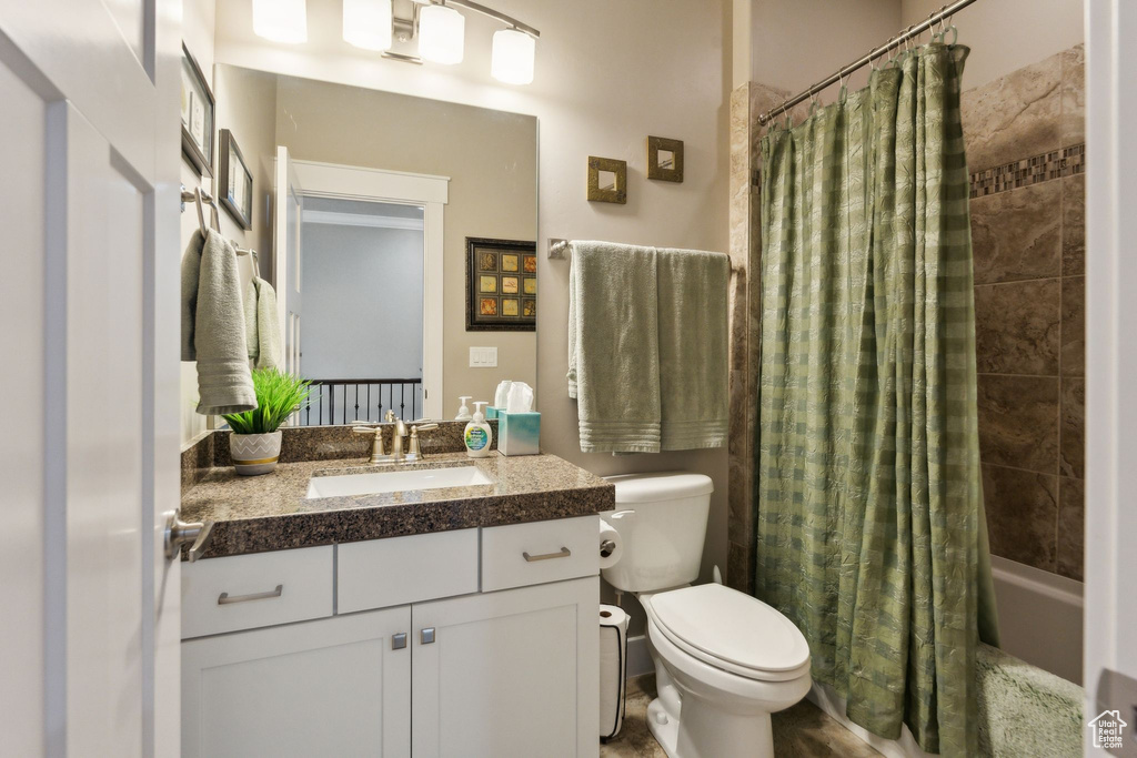 Full bathroom with toilet, shower / tub combo, and vanity