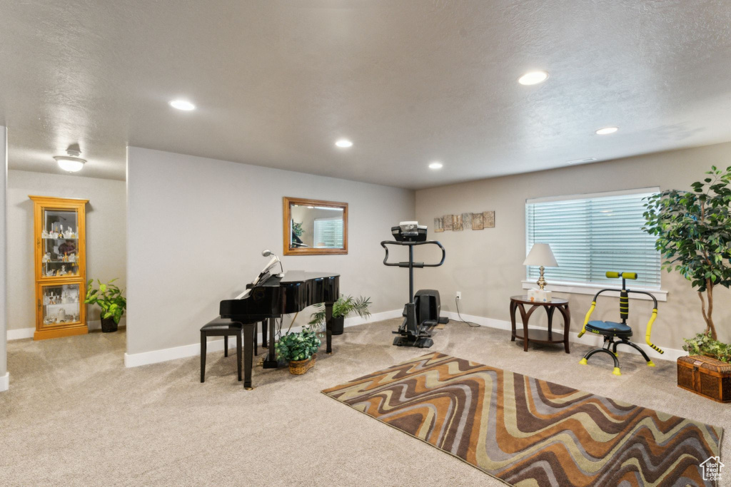 Living area with carpet floors, baseboards, and recessed lighting