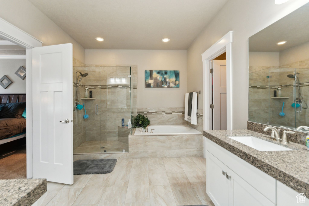 Bathroom featuring a garden tub, a stall shower, connected bathroom, vanity, and recessed lighting