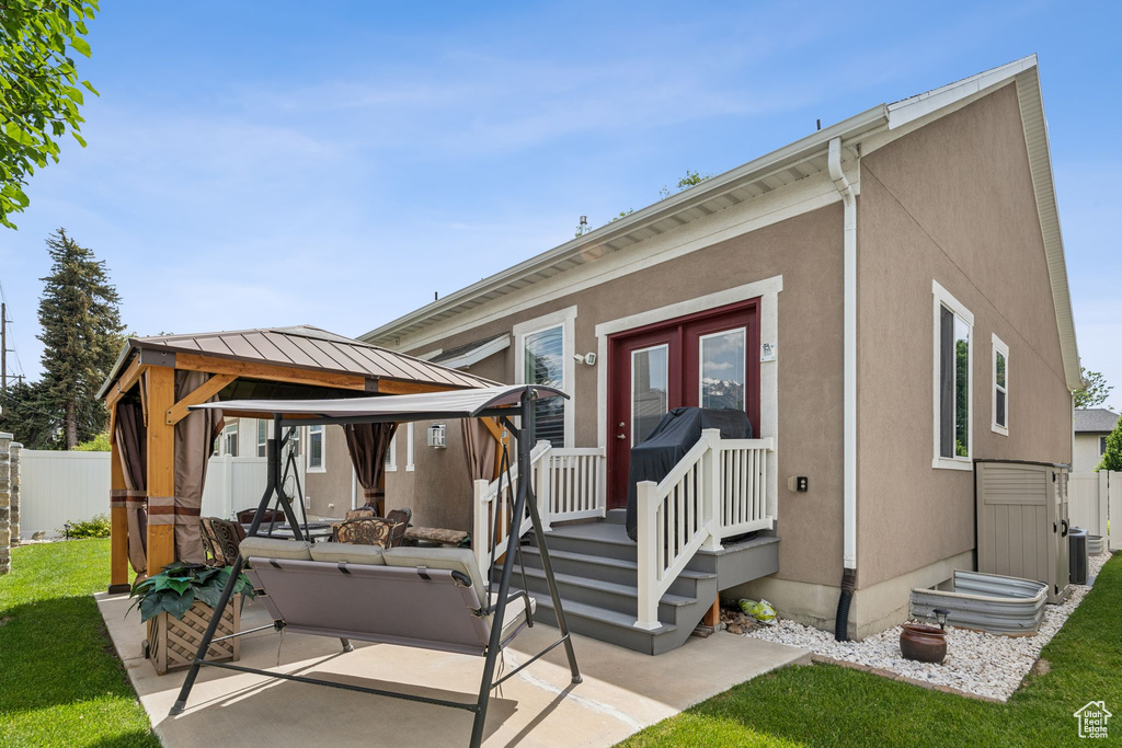 Back of house featuring a gazebo, a patio area, and stucco siding