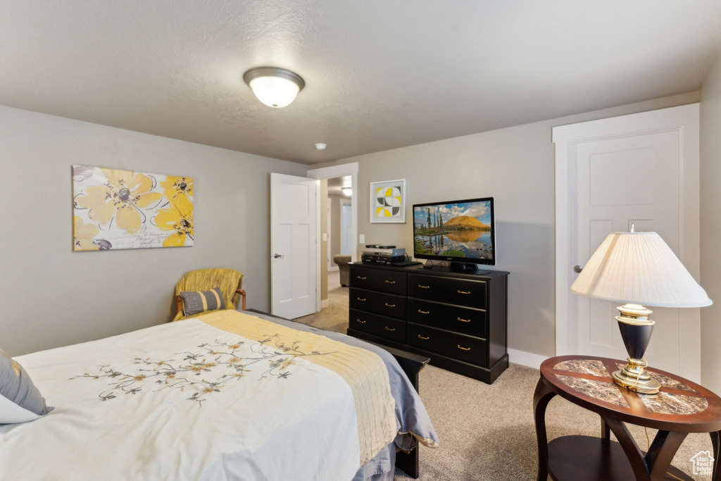 Bedroom with light carpet and baseboards