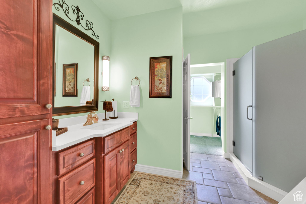Bathroom featuring vanity, stone tile flooring, and a shower stall