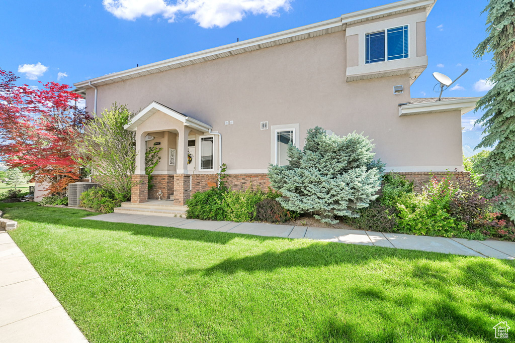 View of front of home featuring a front lawn, stucco siding, and brick siding