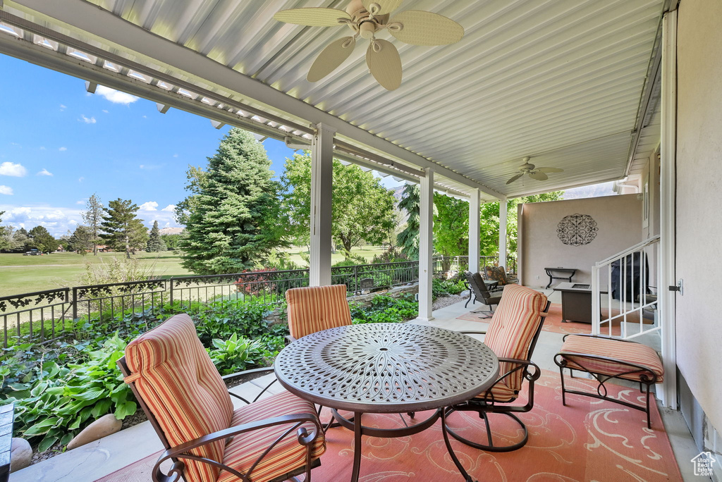View of patio with a ceiling fan and view of golf course