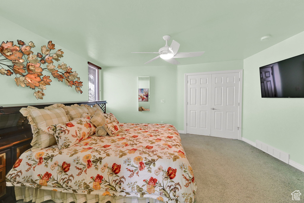 Carpeted bedroom with a closet and ceiling fan