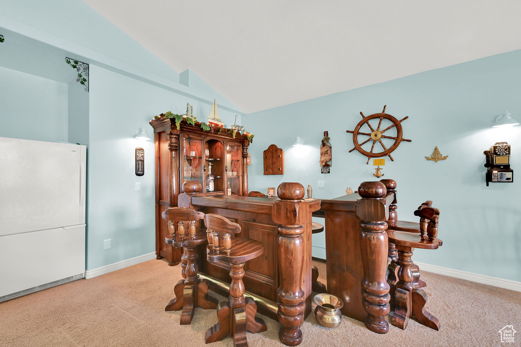 Indoor dry bar featuring carpet and lofted ceiling
