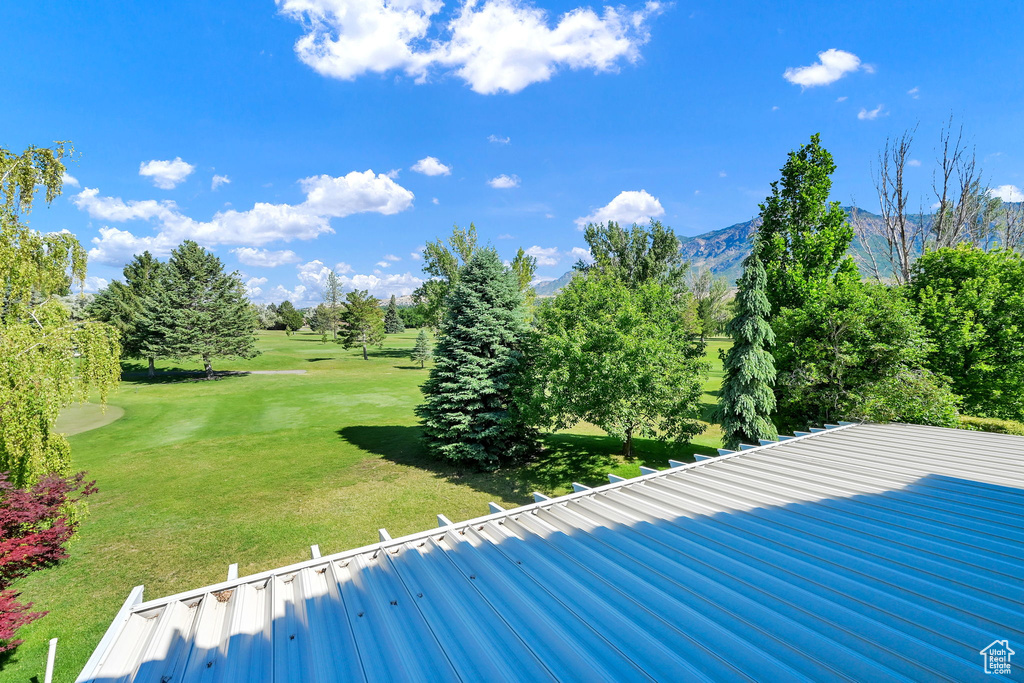 View of grassy yard with a mountain view, view of golf course, and view of scattered trees