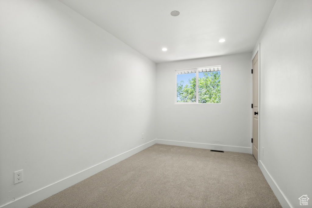 Unfurnished room with light colored carpet and recessed lighting