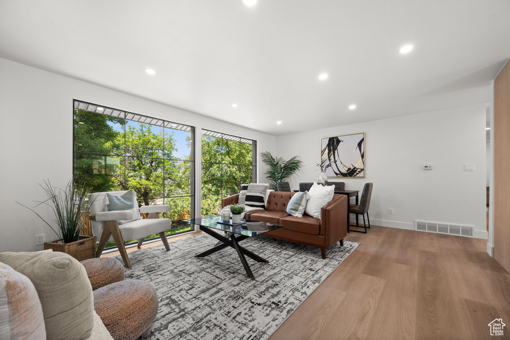 Living room with light wood-type flooring and recessed lighting