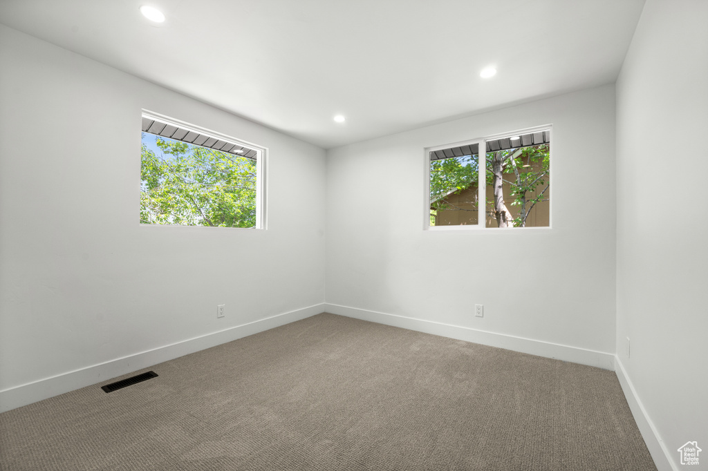 Carpeted empty room with recessed lighting