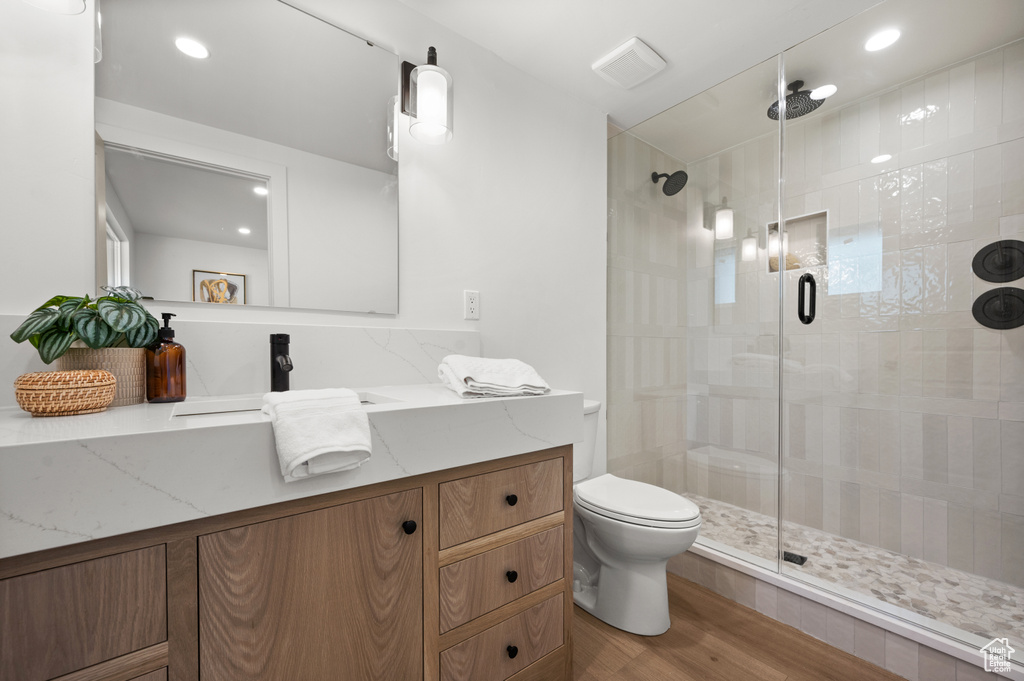 Full bathroom featuring a shower stall, vanity, wood finished floors, and recessed lighting
