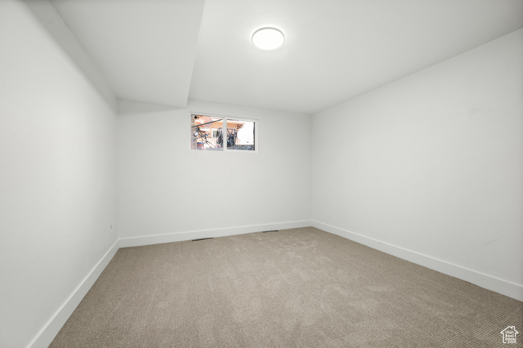 Spare room with light colored carpet and baseboards