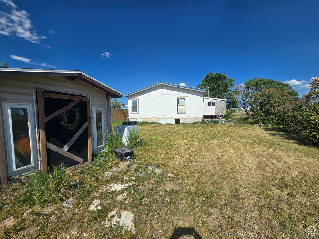 View of green lawn featuring an outbuilding