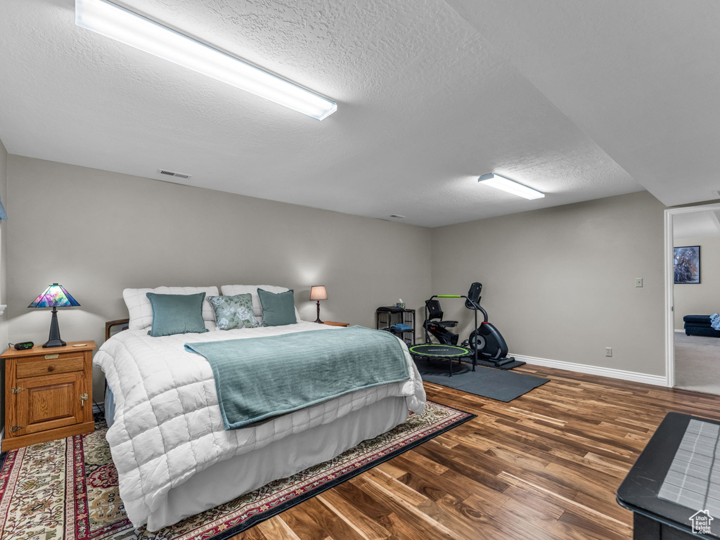 Bedroom featuring a textured ceiling and wood finished floors