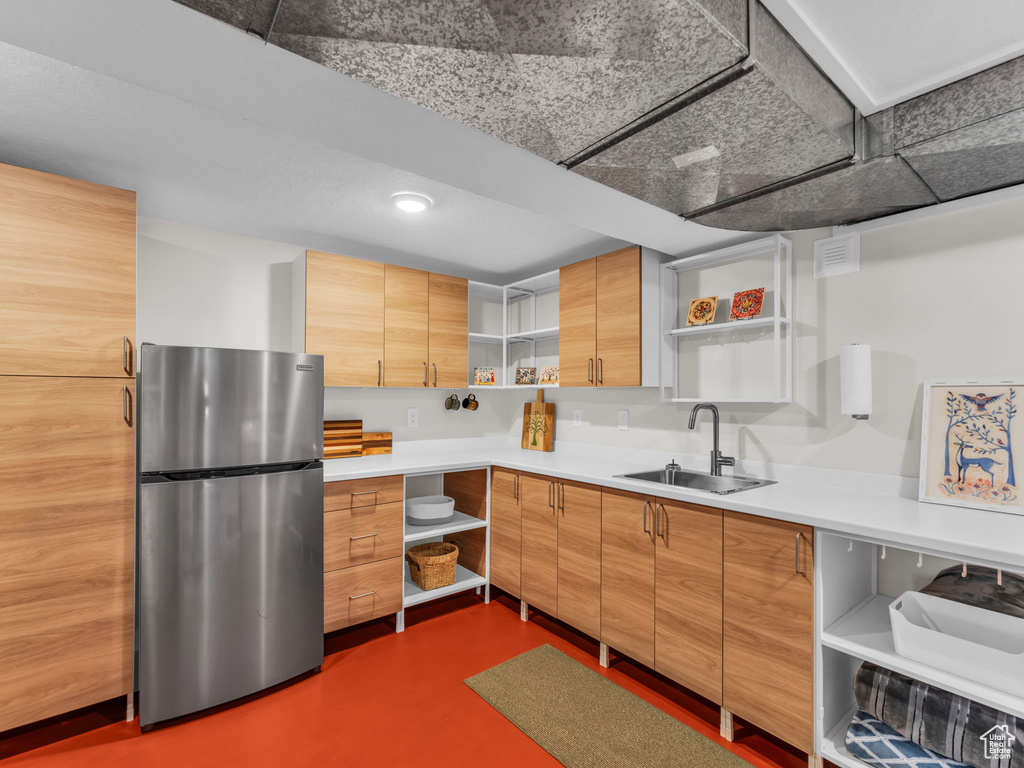 Kitchen with open shelves, freestanding refrigerator, and light countertops