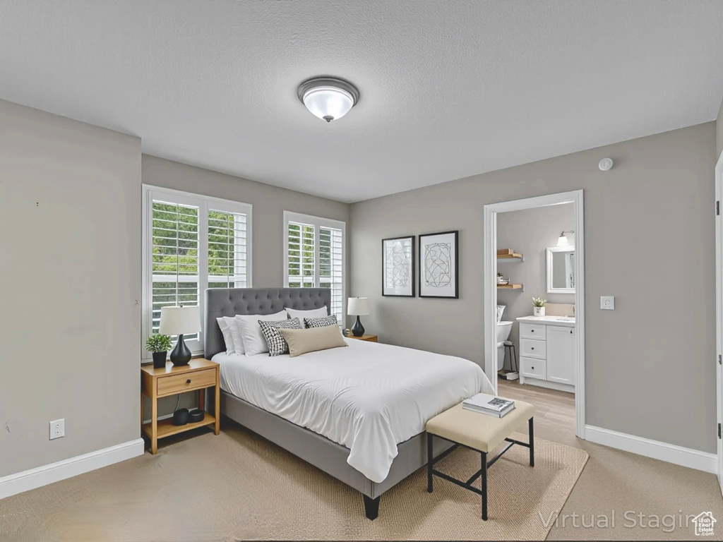 Bedroom with baseboards and connected bathroom