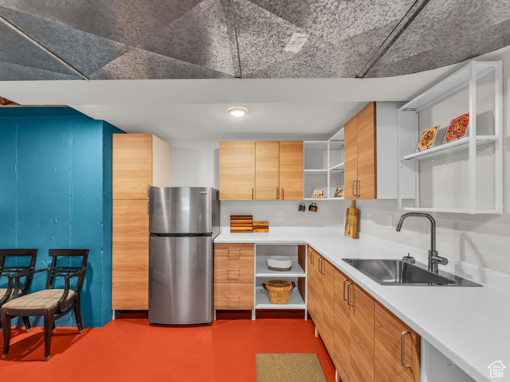 Kitchen with open shelves, freestanding refrigerator, light countertops, and modern cabinets