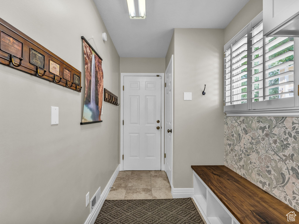Mudroom featuring baseboards and light tile patterned floors