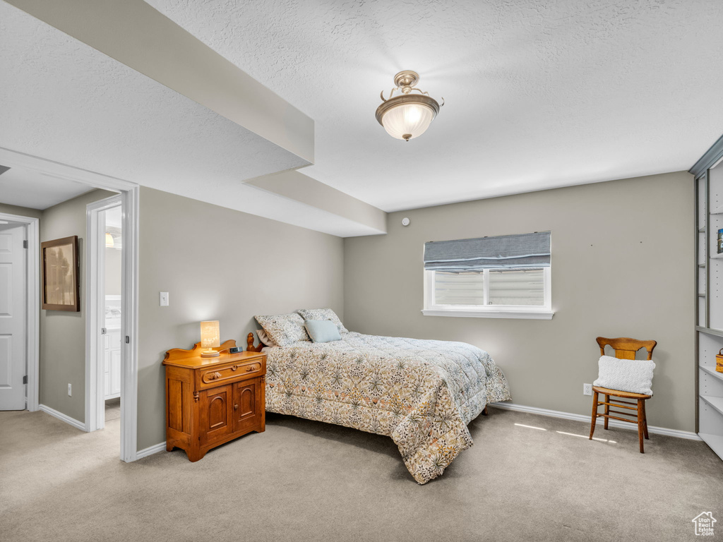 Bedroom featuring light carpet and a textured ceiling