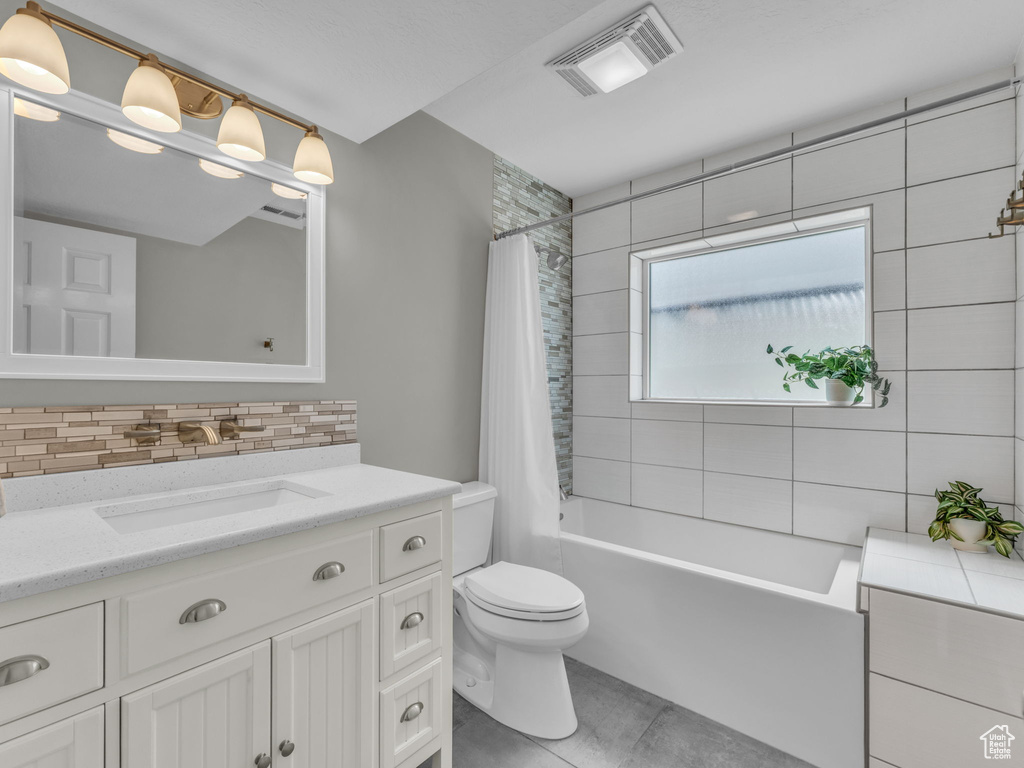 Bathroom with vanity, backsplash, shower / bathtub combination with curtain, and tile patterned floors