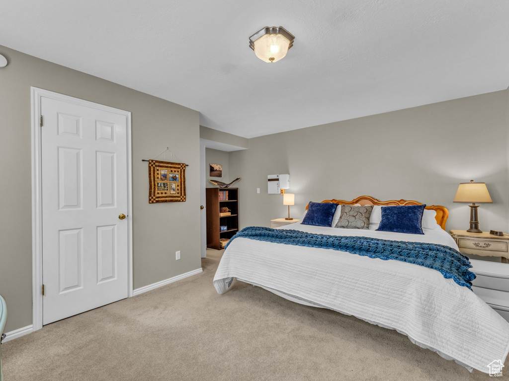 Bedroom with light colored carpet and baseboards