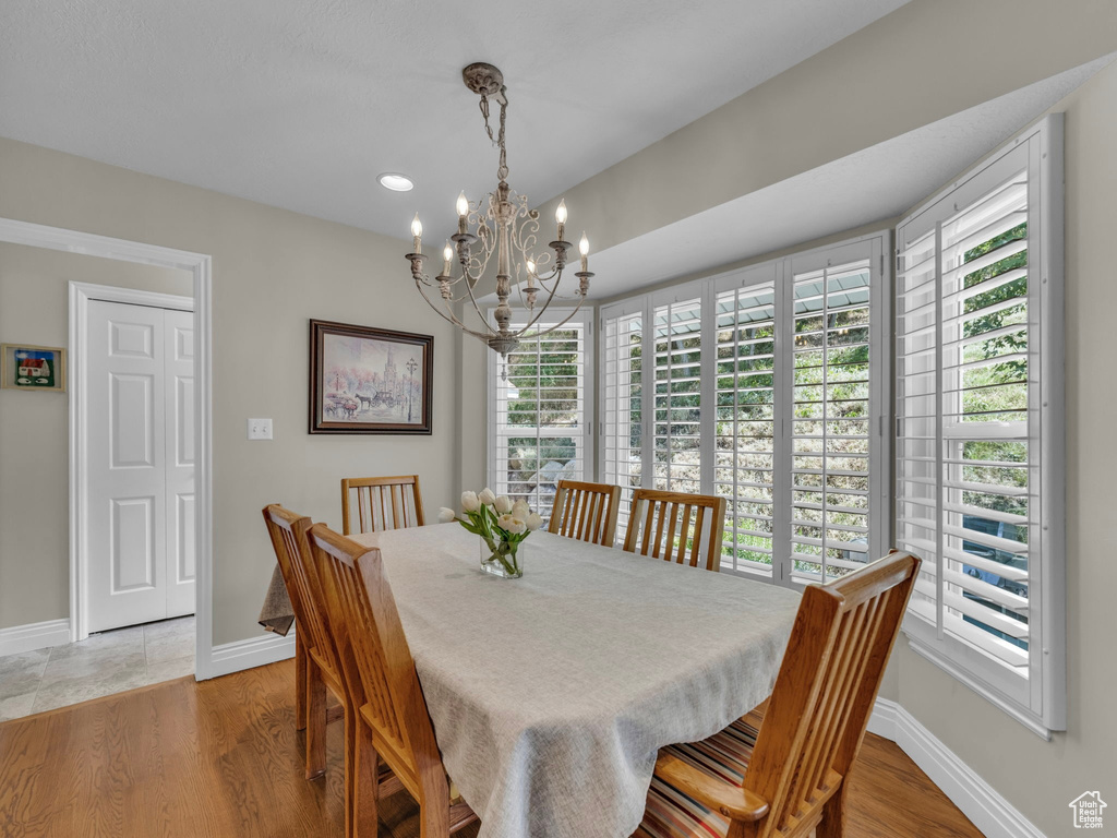 Dining space with a chandelier, healthy amount of natural light, light wood-type flooring, and recessed lighting