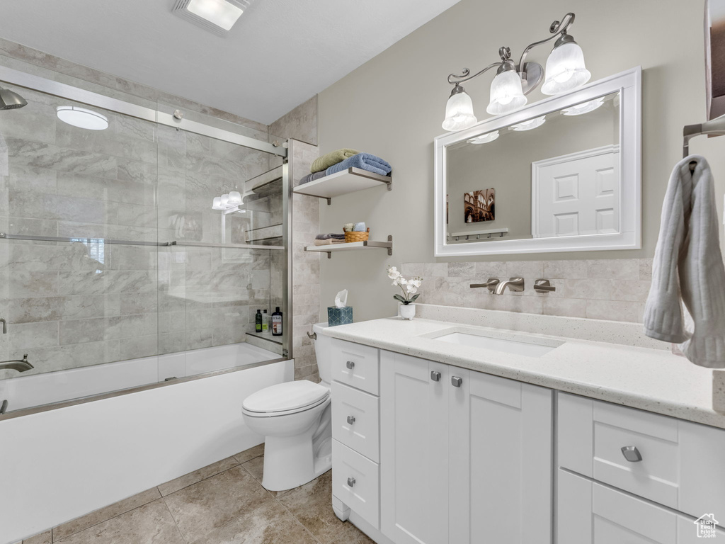 Full bathroom featuring vanity, combined bath / shower with glass door, and tile patterned floors