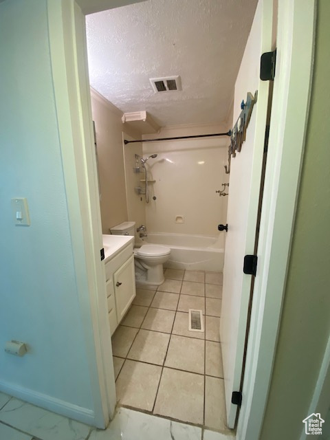 Bathroom featuring vanity, bathing tub / shower combination, a textured ceiling, and tile patterned floors