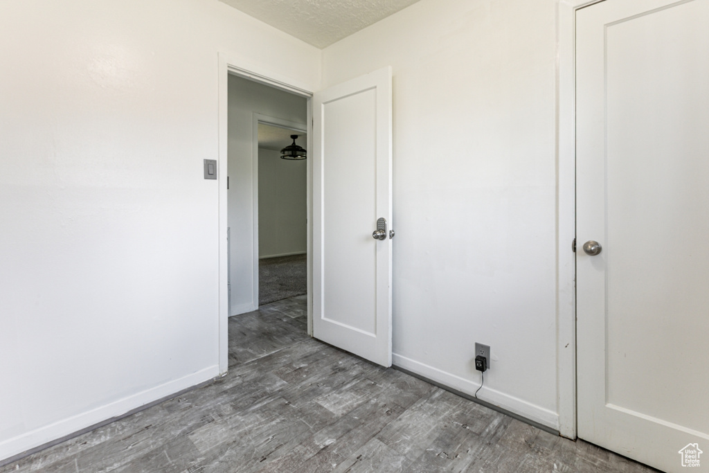 Spare room with wood finished floors and a textured ceiling