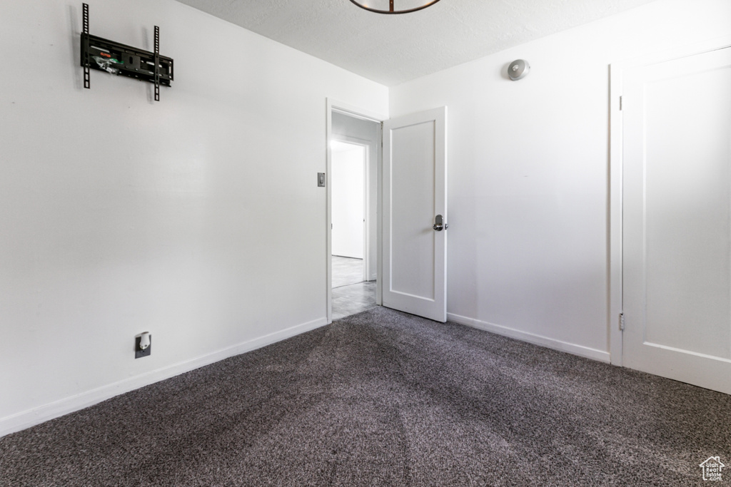 Carpeted spare room featuring baseboards
